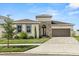 Beautiful single-story home featuring manicured lawn, stone accents and a brick paved driveway leading to a two-car garage at 8297 Ivy Stark Blvd, Wesley Chapel, FL 33545