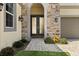 Close up of the main entryway featuring stone accents, a paved walkway, and double doors with decorative metal at 8297 Ivy Stark Blvd, Wesley Chapel, FL 33545