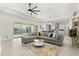 Living room with gray sectional sofa, view of the kitchen, dining area and a sliding glass door to the pool at 8297 Ivy Stark Blvd, Wesley Chapel, FL 33545