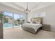 Spacious main bedroom with tray ceilings overlooking a private pool area at 8297 Ivy Stark Blvd, Wesley Chapel, FL 33545