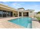 Backyard pool with brick trim, steps, and covered seating perfect for outdoor relaxation at 8297 Ivy Stark Blvd, Wesley Chapel, FL 33545