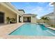 Large brick paved patio featuring a private in-ground pool with fountain and backyard seating area at 8297 Ivy Stark Blvd, Wesley Chapel, FL 33545