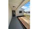 Covered front porch area with gray painted concrete and mulched garden bed next to front door at 12800 Kellywood Cir, Hudson, FL 34669