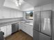 Bright kitchen featuring stainless steel appliances, granite countertops, and white cabinets at 12800 Kellywood Cir, Hudson, FL 34669