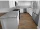 Modern kitchen with white cabinets, granite countertops, stainless steel appliances, and wood flooring at 12800 Kellywood Cir, Hudson, FL 34669