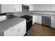 Modern kitchen with white cabinets, granite countertops, stainless steel appliances, and wood floors at 12800 Kellywood Cir, Hudson, FL 34669
