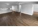 Open-concept living area with wood floors and a view into the modern kitchen at 12800 Kellywood Cir, Hudson, FL 34669