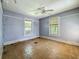 Bedroom with blue walls, ceiling fan, and two windows needs renovation at 226 N Grosse Ave, Tarpon Springs, FL 34689