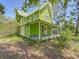 Charming two-story home with a covered front porch, wrapped in mature trees and inviting greenery at 226 N Grosse Ave, Tarpon Springs, FL 34689