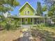 The exterior of the home features a welcoming porch, mature landscaping, and a classic two-story design at 226 N Grosse Ave, Tarpon Springs, FL 34689