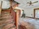 Interior view showcasing the living room with hardwood floors, wood trim, and staircase, revealing renovation potential at 226 N Grosse Ave, Tarpon Springs, FL 34689