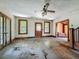 Spacious living room with hardwood floors, ornate trim, and an open doorway, presenting an opportunity for restoration at 226 N Grosse Ave, Tarpon Springs, FL 34689