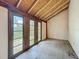 Bright sun room with wood paneled walls, multiple windows and decorative flooring awaiting renovation at 226 N Grosse Ave, Tarpon Springs, FL 34689