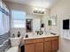Bathroom with a double sink vanity, framed mirror and shower/tub combo at 5009 Clover Mist Dr, Apollo Beach, FL 33572