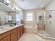 Bathroom showcasing a double vanity, bathtub, and separate glass-enclosed shower for optimal comfort at 5009 Clover Mist Dr, Apollo Beach, FL 33572