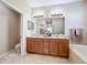 Bathroom featuring a double vanity, tub, and toilet room for added convenience and functionality at 5009 Clover Mist Dr, Apollo Beach, FL 33572