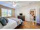 Bedroom showcasing hardwood floors, a ceiling fan, neutral walls, and an open doorway to the kitchen at 5009 Clover Mist Dr, Apollo Beach, FL 33572