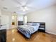 Spacious bedroom with hardwood floors, ceiling fan, ensuite bath, and neutral walls for a relaxing atmosphere at 5009 Clover Mist Dr, Apollo Beach, FL 33572