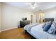 Bedroom featuring hardwood floors, a ceiling fan, neutral walls, and an open doorway to the bathroom at 5009 Clover Mist Dr, Apollo Beach, FL 33572