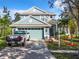 Charming two-story home with a well-manicured lawn, mature trees and a light blue exterior color scheme at 5009 Clover Mist Dr, Apollo Beach, FL 33572