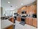Well-equipped kitchen with stainless steel appliances, wood cabinets, and tile flooring at 5009 Clover Mist Dr, Apollo Beach, FL 33572