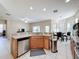 Open kitchen design with stainless steel appliances, tiled flooring, and a view of the dining area at 5009 Clover Mist Dr, Apollo Beach, FL 33572
