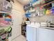 The laundry room offers plenty of storage space with wire shelving and a front-load washer/dryer at 5009 Clover Mist Dr, Apollo Beach, FL 33572