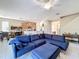 Bright and airy living room with a large blue sectional couch, ceiling fan and tile flooring at 5009 Clover Mist Dr, Apollo Beach, FL 33572