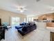 Open-concept living room showcasing a blue sectional, tile floors, and natural light from sliding glass doors at 5009 Clover Mist Dr, Apollo Beach, FL 33572