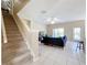 Bright living room with tile flooring, neutral paint, a ceiling fan, a staircase, and sliding door access to outdoors at 5009 Clover Mist Dr, Apollo Beach, FL 33572