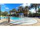Community pool with palm trees and a decorative fountain, lined with seating and umbrellas at 1079 Signet, Apollo Beach, FL 33572