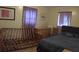 A simple bedroom with purple curtains, standard furnishings, and neutral-toned walls at 3680 Whiting Se Dr, St Petersburg, FL 33705
