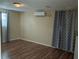 Simple bedroom featuring wood-look floors, neutral walls, and an air conditioning unit at 3680 Whiting Se Dr, St Petersburg, FL 33705
