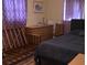 A simple bedroom with purple curtains, standard furnishings, and neutral-toned walls at 3680 Whiting Se Dr, St Petersburg, FL 33705