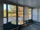 Bright Florida Room with view of fenced-in back yard, glass table and blue accent rug at 3680 Whiting Se Dr, St Petersburg, FL 33705