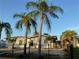 Inviting single-story residence with a black metal fence, complemented by lush palm trees and a rock lawn at 3680 Whiting Se Dr, St Petersburg, FL 33705