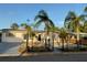 Neat single-story home with a black metal fence, with mature palms and a well-maintained rock front yard at 3680 Whiting Se Dr, St Petersburg, FL 33705