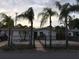 Charming single-story home with a well-kept lawn, mature palm trees, and a black metal fence at 3680 Whiting Se Dr, St Petersburg, FL 33705