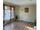 Bright living room with wood-look flooring, large windows, and decorative curtains at 3680 Whiting Se Dr, St Petersburg, FL 33705