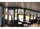 A bright sunroom with multiple windows, sheer blue curtains, and casual seating at 3680 Whiting Se Dr, St Petersburg, FL 33705
