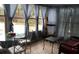 A bright sunroom with multiple windows, sheer blue curtains, and casual seating at 3680 Whiting Se Dr, St Petersburg, FL 33705