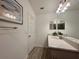 Bright bathroom featuring a quartz countertop, wood look flooring, and framed wall art at 4171 Via Sienna Cir, Sarasota, FL 34243