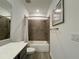 Modern bathroom with dark gray tiled shower/tub, gray vanity, and quartz countertop at 4171 Via Sienna Cir, Sarasota, FL 34243