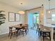Cozy dining area with modern lighting, sliding glass doors to patio, adjacent to a breakfast bar at 4171 Via Sienna Cir, Sarasota, FL 34243