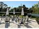 Community pool area with shaded lounge chairs and tables for relaxing by the water at 4171 Via Sienna Cir, Sarasota, FL 34243