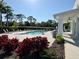 Inviting community pool with lounge chairs, lush landscaping, and a covered pavilion at 4171 Via Sienna Cir, Sarasota, FL 34243