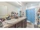 Bathroom featuring a dual vanity with dark wood cabinetry, white sinks and a walk in shower at 819 Lucent Sands Ct, Brandon, FL 33511