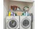 Functional laundry room with washer, dryer, and shelving for convenient storage at 819 Lucent Sands Ct, Brandon, FL 33511