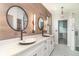 Luxurious bathroom featuring dual sinks, custom wood panelling, decorative floor tiling, and access to a large shower at 20323 Granlago Dr, Venice, FL 34293