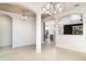 Open dining room with tile floors, modern chandeliers, and open view to the kitchen and a room featuring a black accent wall at 20323 Granlago Dr, Venice, FL 34293